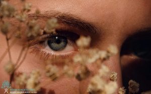 A close up of a woman's face with blue eyes.