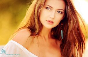 A beautiful woman with long brown hair posing for a photo.