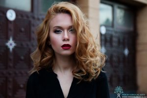 A young woman with red lips is posing for a photo.